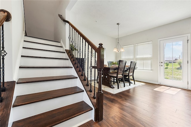 stairs with an inviting chandelier and hardwood / wood-style flooring