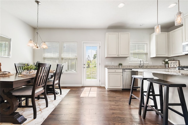 kitchen featuring decorative light fixtures, white cabinets, stainless steel appliances, and dark hardwood / wood-style floors