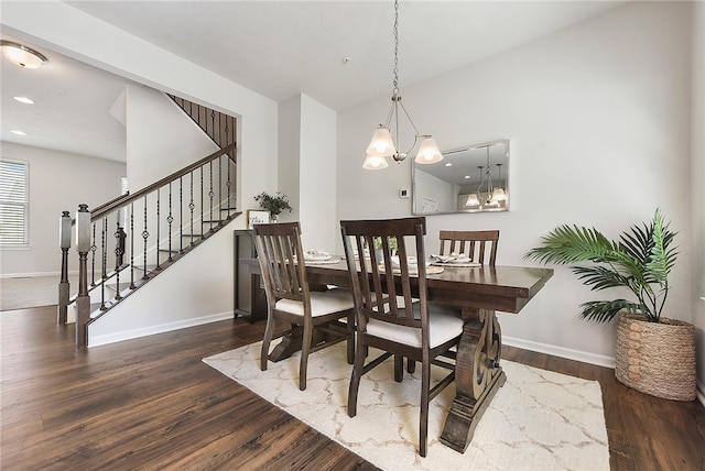 dining room with dark wood-type flooring and a notable chandelier