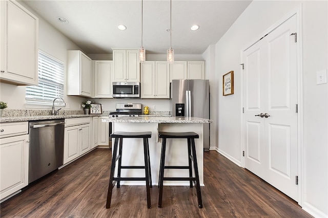 kitchen featuring a center island, stainless steel appliances, white cabinetry, and dark wood-type flooring