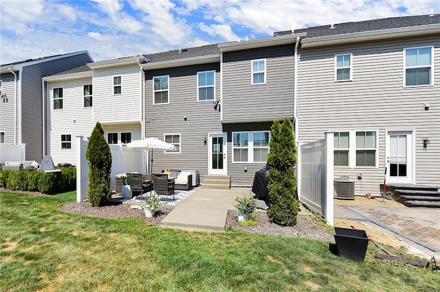 rear view of house featuring a lawn, a patio area, and central AC unit