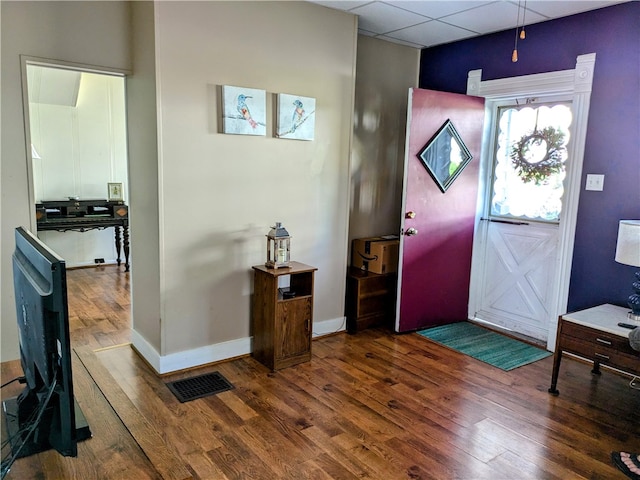 entrance foyer with hardwood / wood-style floors and a drop ceiling