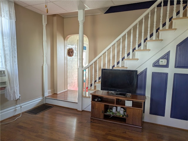 entryway featuring a drop ceiling, dark hardwood / wood-style floors, and decorative columns