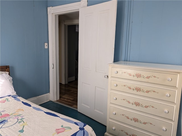 bedroom featuring wood walls and dark wood-type flooring