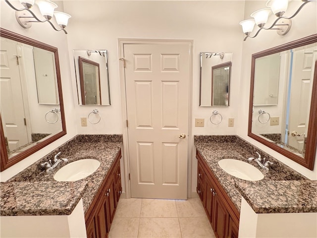 bathroom with vanity, an inviting chandelier, and tile patterned floors