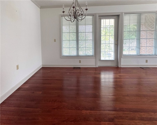 unfurnished dining area with dark wood-type flooring, crown molding, and a notable chandelier