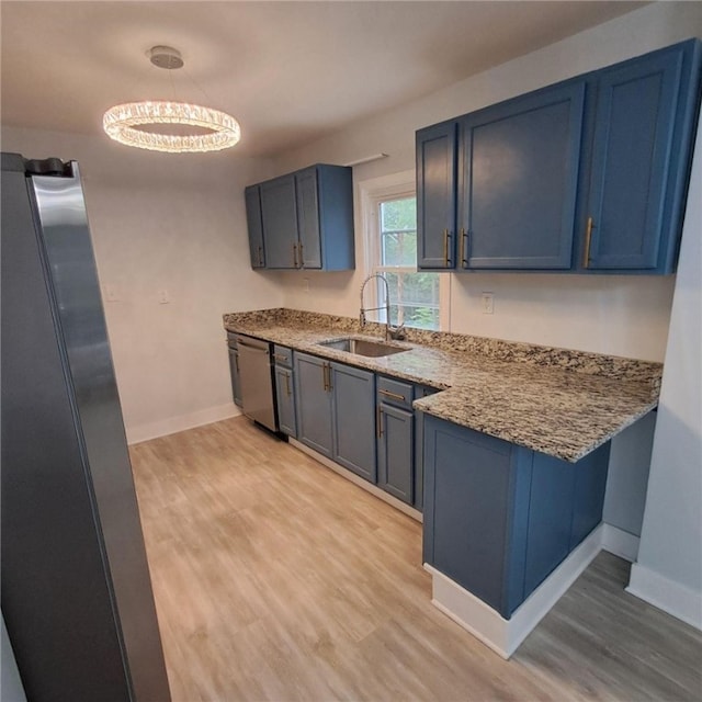 kitchen featuring light wood-type flooring, appliances with stainless steel finishes, blue cabinets, and sink