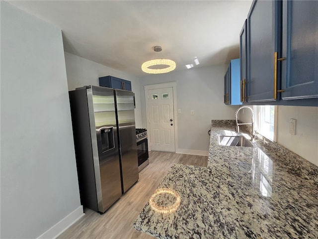 kitchen with appliances with stainless steel finishes, light hardwood / wood-style floors, stone countertops, sink, and blue cabinets