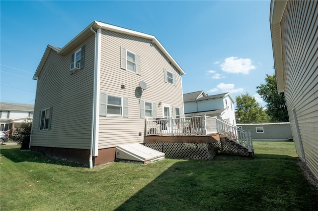 rear view of house featuring a yard and a deck