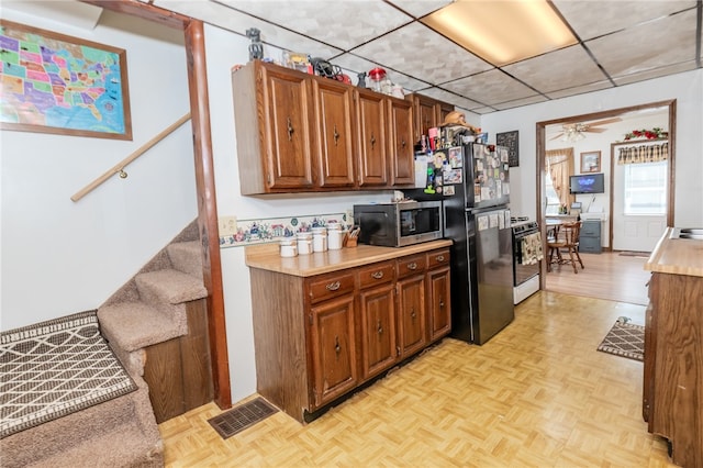 kitchen with ceiling fan, appliances with stainless steel finishes, and light parquet flooring