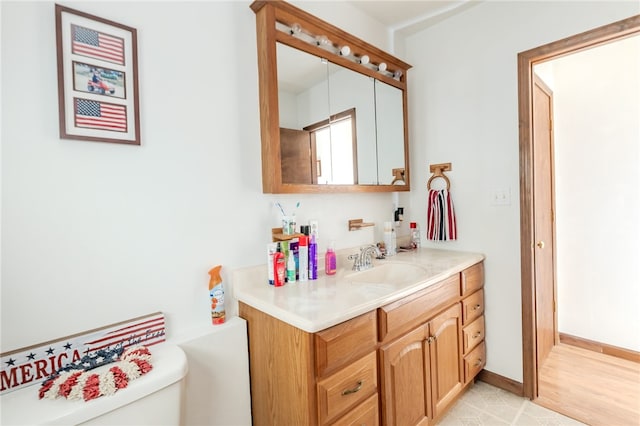 bathroom featuring vanity, hardwood / wood-style flooring, and toilet