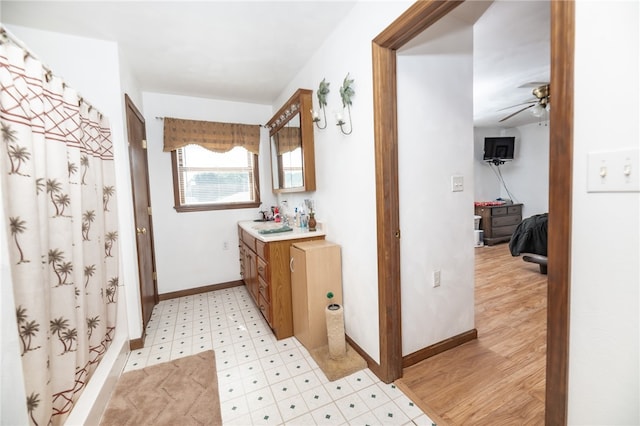 bathroom with ceiling fan, hardwood / wood-style floors, vanity, and walk in shower