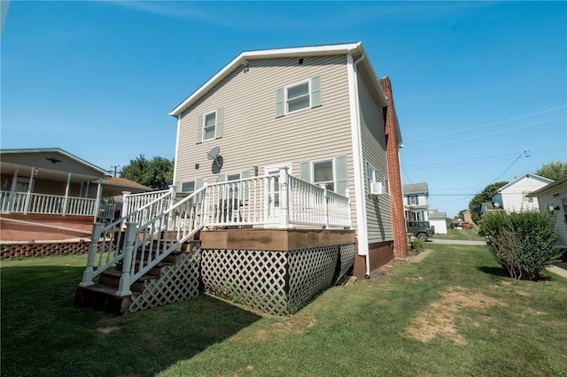 back of house featuring a wooden deck and a lawn