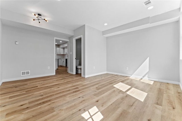 unfurnished living room with visible vents, baseboards, and wood finished floors