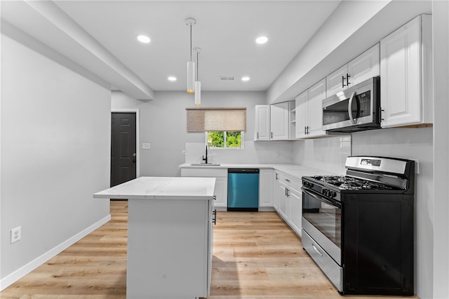 kitchen featuring a sink, a center island, light wood-style floors, and stainless steel appliances