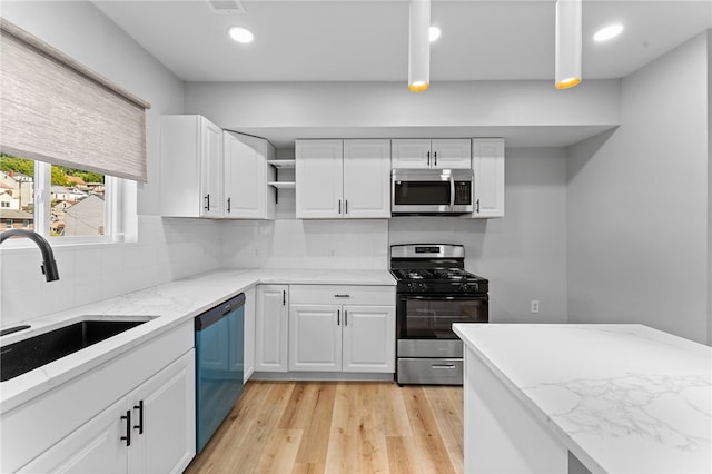 kitchen featuring tasteful backsplash, a sink, light stone counters, appliances with stainless steel finishes, and open shelves