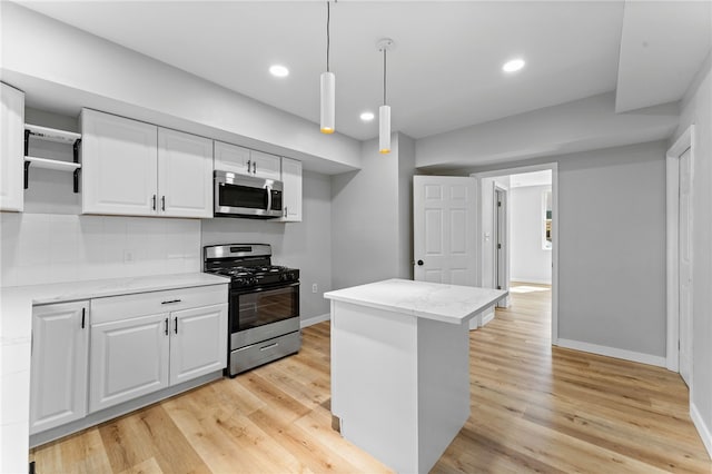 kitchen featuring white cabinets, light wood-style floors, tasteful backsplash, and appliances with stainless steel finishes