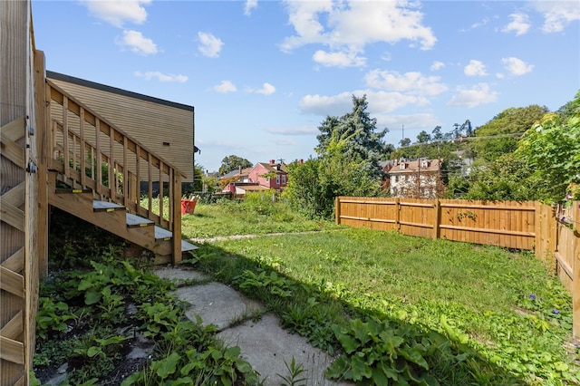 view of yard featuring stairway and fence