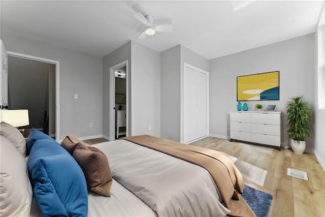 bedroom with visible vents, ensuite bathroom, wood finished floors, baseboards, and ceiling fan