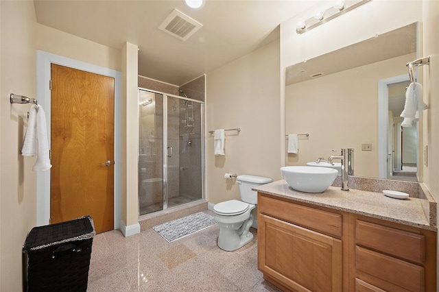 bathroom featuring a shower with door, vanity, and toilet