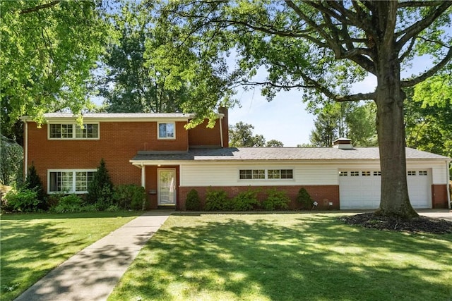 traditional-style house with an attached garage, a chimney, brick siding, and a front yard