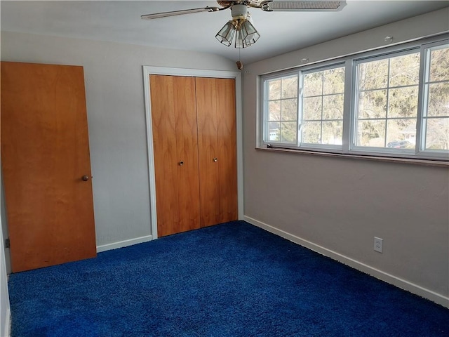 unfurnished bedroom featuring ceiling fan, a closet, and dark colored carpet