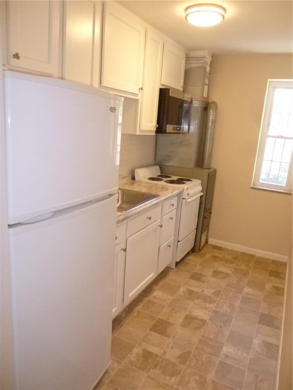 kitchen featuring white cabinets, white appliances, and sink