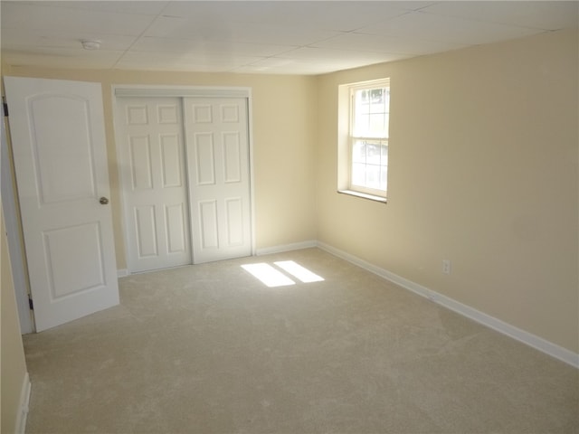 unfurnished bedroom with a closet and light carpet