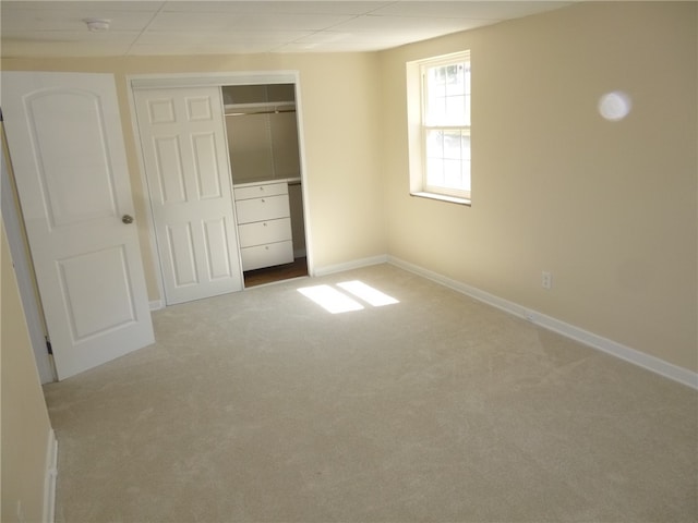 unfurnished bedroom featuring light colored carpet and a closet