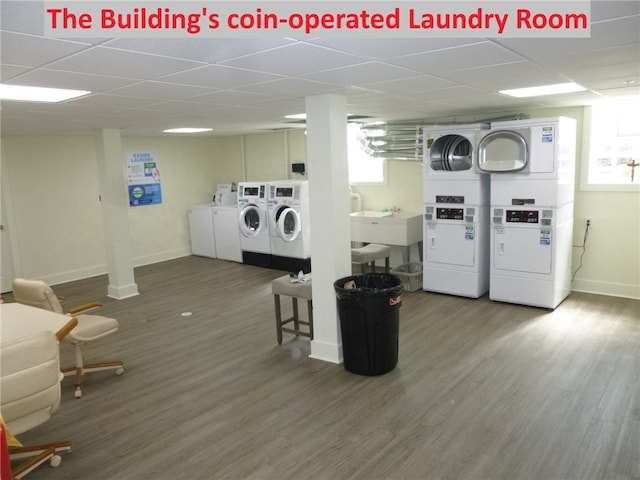 laundry area with wood-type flooring, stacked washing maching and dryer, and washing machine and clothes dryer