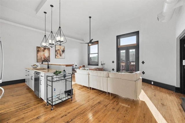 kitchen featuring dishwasher, pendant lighting, a sink, and light wood-style floors