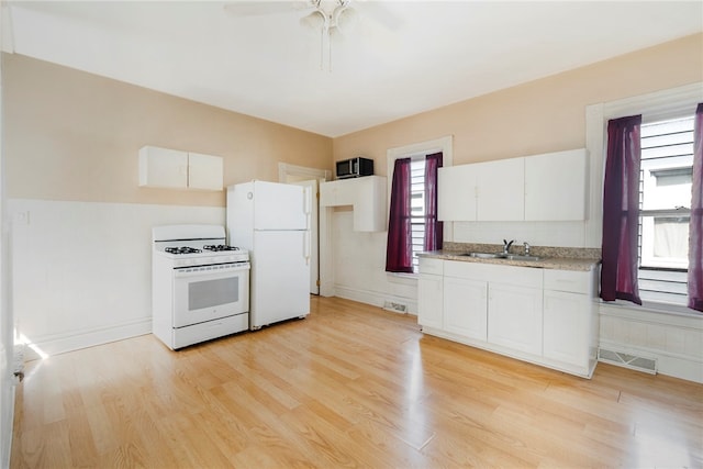 kitchen with white appliances, light hardwood / wood-style floors, sink, ceiling fan, and white cabinets