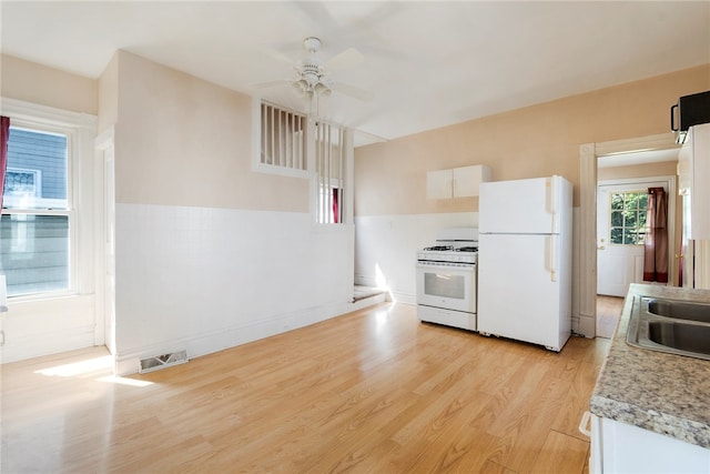 kitchen featuring white appliances, light hardwood / wood-style floors, sink, ceiling fan, and white cabinets