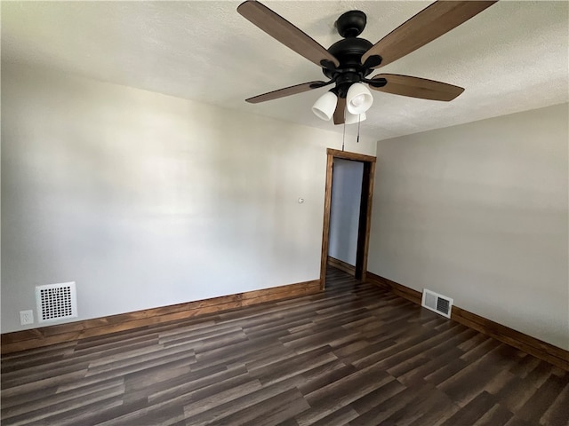 empty room featuring dark wood-type flooring, ceiling fan, and a textured ceiling