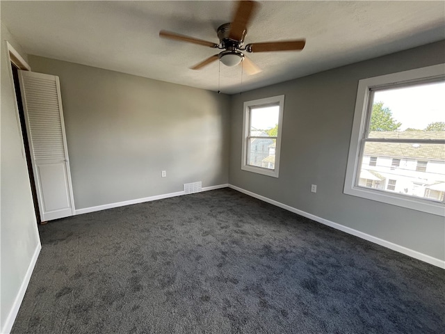 carpeted spare room with a textured ceiling and ceiling fan