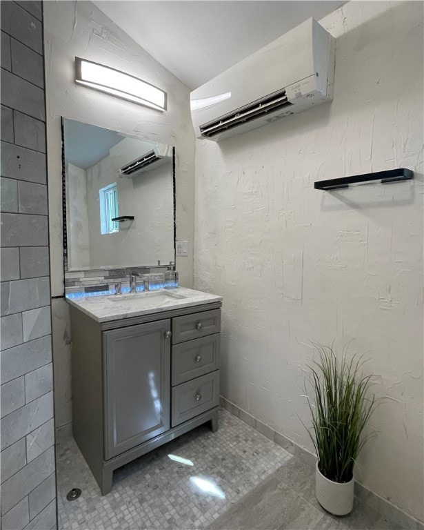 bathroom featuring tile patterned flooring, vanity, and an AC wall unit