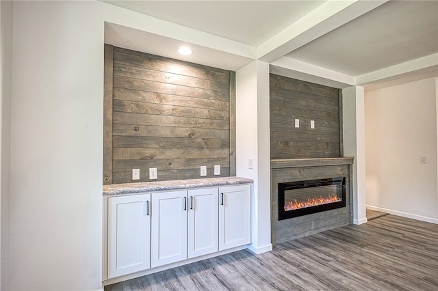 bar with white cabinetry, hardwood / wood-style floors, and light stone counters