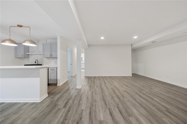 kitchen with gray cabinets, wood-type flooring, and pendant lighting