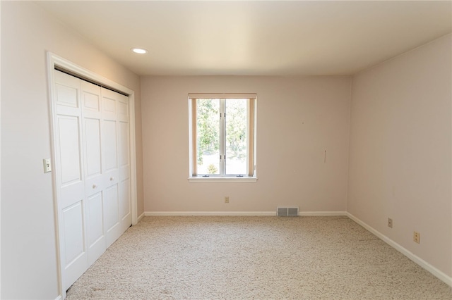 unfurnished bedroom featuring carpet and a closet