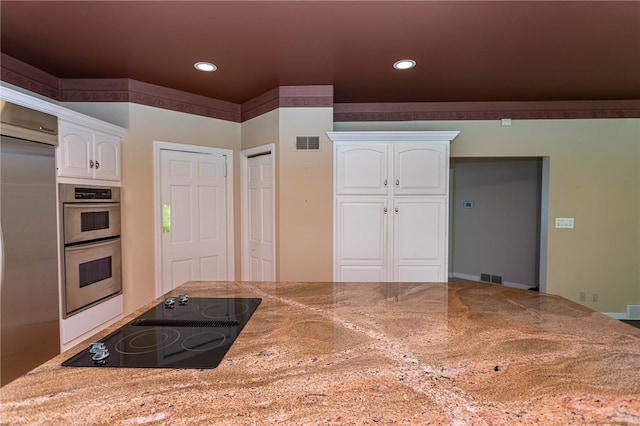 kitchen featuring appliances with stainless steel finishes, light stone counters, and white cabinets