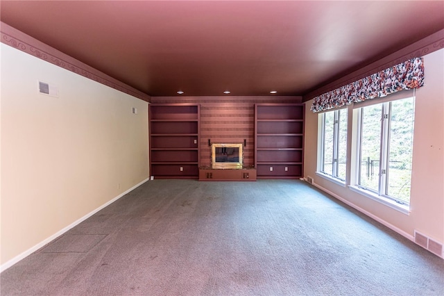 unfurnished living room featuring built in features, carpet, and a fireplace