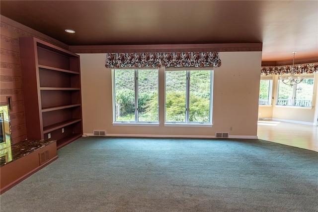 unfurnished living room with carpet flooring and an inviting chandelier