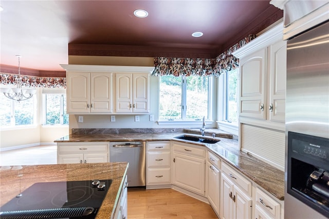 kitchen with light hardwood / wood-style flooring, dark stone countertops, sink, and appliances with stainless steel finishes