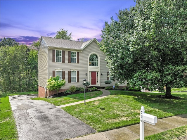 colonial inspired home featuring a yard