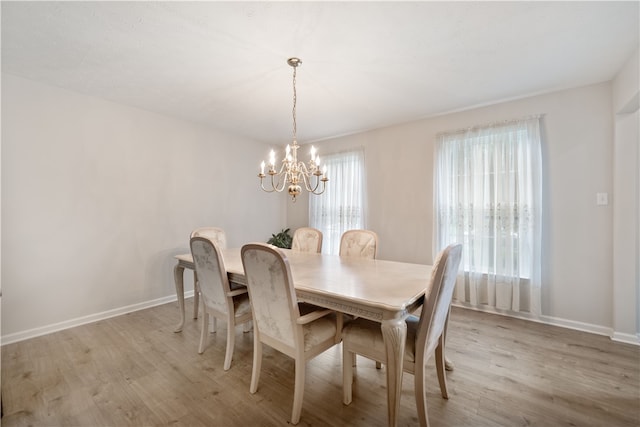 dining space with an inviting chandelier and light hardwood / wood-style floors