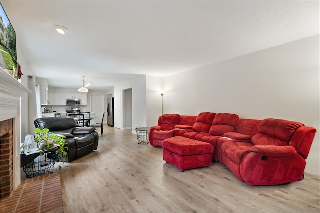 living room featuring light wood-type flooring and a fireplace