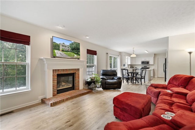 living room with light wood-type flooring and a fireplace