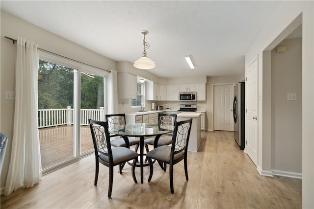 dining room featuring sink and light hardwood / wood-style flooring