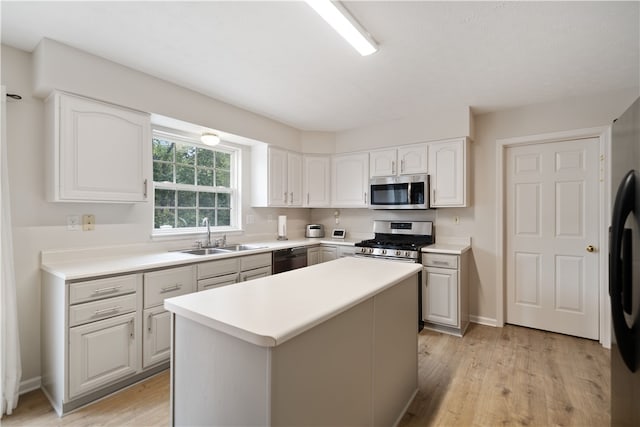 kitchen with white cabinetry, stainless steel appliances, sink, and light hardwood / wood-style floors