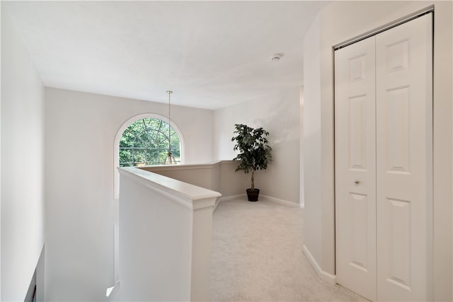 hallway featuring light colored carpet